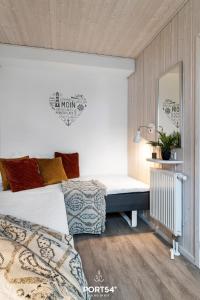 a bedroom with a bed and a mirror in it at Ferienhaus Marina Lounge Wendtorf in Wendtorf