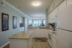 a kitchen with white cabinets and a white refrigerator at Legacy I 407 in Gulfport