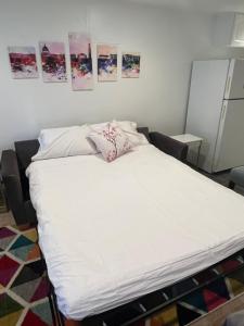 uma grande cama branca num quarto com fotografias na parede em Logan Circle Living em Washington