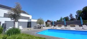 une piscine en face d'un bâtiment dans l'établissement Luxe Vakantievilla - B&B Blue Garden Vlaamse Ardennen nabij Pairi Daiza, à Grammont
