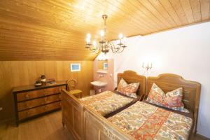 um quarto com uma cama e um tecto de madeira em Chasa Muglinér 115 em Scuol