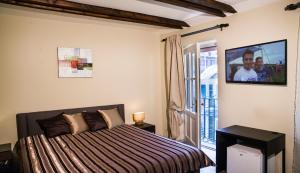Dům U pikové desítky في برنو: غرفة نوم مع سرير وتلفزيون على الحائط