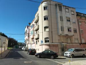 ein Gebäude an der Seite einer Straße mit geparkten Autos in der Unterkunft Lisboa - Moscavide, Parque das Nações Apartment in Lissabon