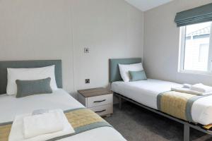 a bedroom with two beds and a window at Ribble Valley Country and Leisure Park 