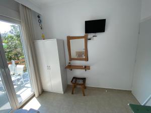 a room with a mirror and a tv and a chair at Delikos House in Limenaria