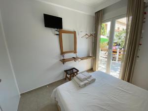 a bedroom with a bed and a mirror and a window at Delikos House in Limenaria