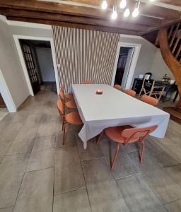 una mesa blanca y sillas en una habitación en La Jacquerie en Baye