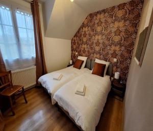 1 dormitorio con 2 camas con sábanas blancas y pared en La Jacquerie en Baye