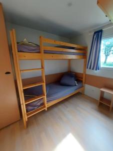 two bunk beds in a room with a window at Les Roses de Jonzac in Mortiers