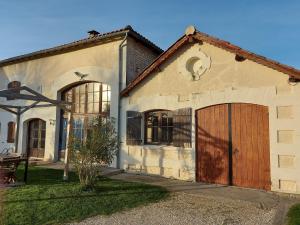 una casa con una gran puerta de madera en garaje en Les Roses de Jonzac, en Mortiers