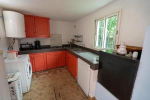 - une cuisine avec des placards rouges et un lave-vaisselle blanc dans l'établissement Villa Enya Élégance&Authenticité, à Tanger