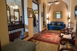 - un salon avec un canapé bleu et un escalier dans l'établissement Villa Enya Élégance&Authenticité, à Tanger