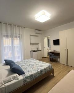 a bedroom with a bed and a desk in it at Oltremare rooms Agropoli in Agropoli