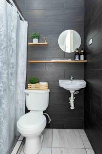 a bathroom with a white toilet and a sink at Habitación Deluxe Tierra - Villa Valle Campo in Nahuizalco