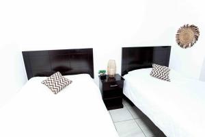 2 letti in una camera da letto con pareti bianche di Habitación Deluxe Tierra - Villa Valle Campo 