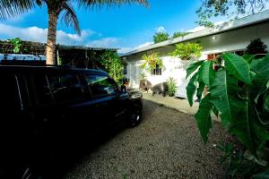a black truck parked in front of a house with a dog at Habitación Deluxe Tierra - Villa Valle Campo in Nahuizalco