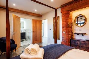 ein Schlafzimmer mit einem Bett und einer Ziegelwand in der Unterkunft Pigeon House - Renovated barn with hot tub and private garden in Shrewsbury