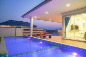 a swimming pool in front of a house at Temmy Pool Villa, Chaam - Hua Hin in Phetchaburi