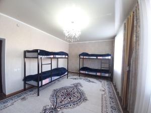 two bunk beds in a room with a chandelier at Askar Guesthouse in Karakol