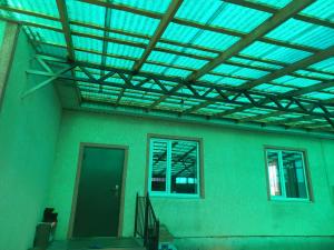 Askar Guesthouse في كاراكول: مبنى بسقف مع نافذة وباب