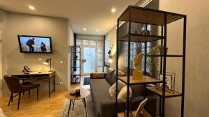 uma sala de estar com um sofá e uma televisão na parede em BEA-001 1 Zimmer Studio-Apartment in Erlensee em Erlensee
