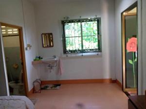 a bathroom with a sink and a window at Chalisa Bukit House Lanta in Ban Mo Nae