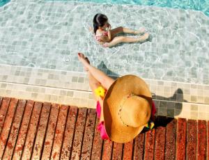 una joven en una piscina con una mujer en Amazon Premium Lodge, en Careiro