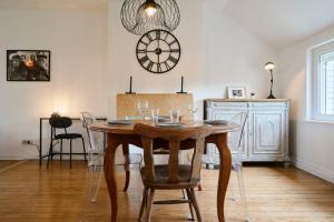 a dining room with a table and a clock on the wall at Superbe appartement art deco tout équipé pour 2 ! in Marcq-en-Baroeul +28 photos