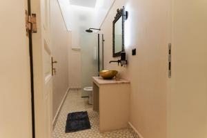 a bathroom with a sink and a toilet and a mirror at Villa Clio, a Luxury Collection in Thessaloniki