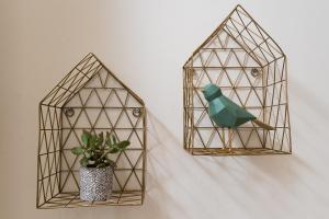 two metal birdhouses hanging on a wall with a plant at Villa Clio, a Luxury Collection in Thessaloniki