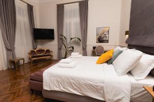 a bedroom with a large bed with white sheets and yellow pillows at Villa Clio, a Luxury Collection in Thessaloniki