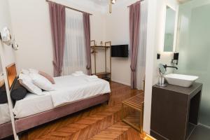 a bedroom with a bed and a sink and a mirror at Villa Clio, a Luxury Collection in Thessaloniki