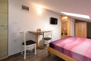 a bedroom with a bed and a table with chairs at Apartments Gabi in Punat
