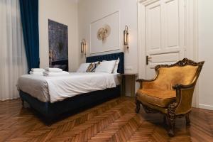 a bedroom with a bed and a chair at Villa Clio, a Luxury Collection in Thessaloniki