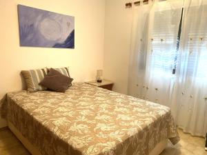 een slaapkamer met een bed en een raam bij Apartamento na praia dona Ana - Iberlagos in Lagos