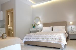 萨索斯luxury studios & apartments Athanasias的一间带床和镜子的白色卧室