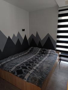 a bedroom with a bed with a mountain mural on the wall at Apartment Triangle in Divčibare