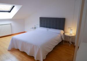 een slaapkamer met een groot wit bed en een raam bij 33 Pasos Catedral 3 in León