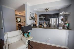 a kitchen with a counter and a chair in a room at I14 - DFW Condo Near Baylor 2BD/1BA in Irving