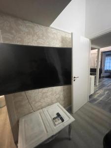 sala de estar con TV de pantalla plana grande en la pared en Sguardo sul lago en Trevignano Romano