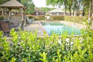 a swimming pool in a yard with a gazebo at I14 - DFW Condo Near Baylor 2BD/1BA in Irving