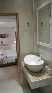 a bathroom with a white sink and a bedroom at luxury studios ath in Limenas