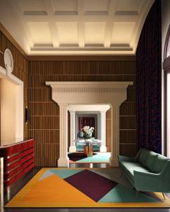 una sala de estar con una silla verde y una alfombra colorida en Room Mate Luca, en Florencia