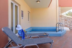 アギア・マリーナ・ネア・キドニアスにあるEurohotel Theo Hotelの椅子2脚とスイミングプールが備わる客室です。
