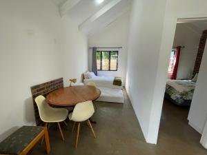 a room with a table and chairs and a bed at The Stables, Central Garden Cottage in Howick in Howick