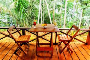 een houten tafel en stoelen op een houten terras bij Amazon Premium Lodge in Careiro