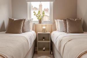 two beds sitting next to each other in a bedroom at Stylish & recently refurbished Chester apartment - Up to 6 in Chester
