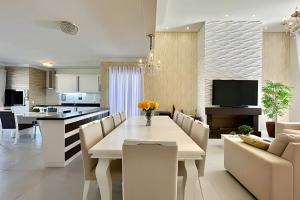 ein Esszimmer und eine Küche mit einem weißen Tisch und Stühlen in der Unterkunft Casa 4 Suítes com piscina Fundos Lago-Ilhas Resort in Capão da Canoa