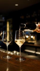 a bottle of wine being poured into two wine glasses at Boston Hotel HH in Hamburg