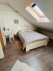 ein Schlafzimmer mit einem Bett und einem Schreibtisch im Dachgeschoss in der Unterkunft Charmante maison de ville au cœur de Fismes in Fismes